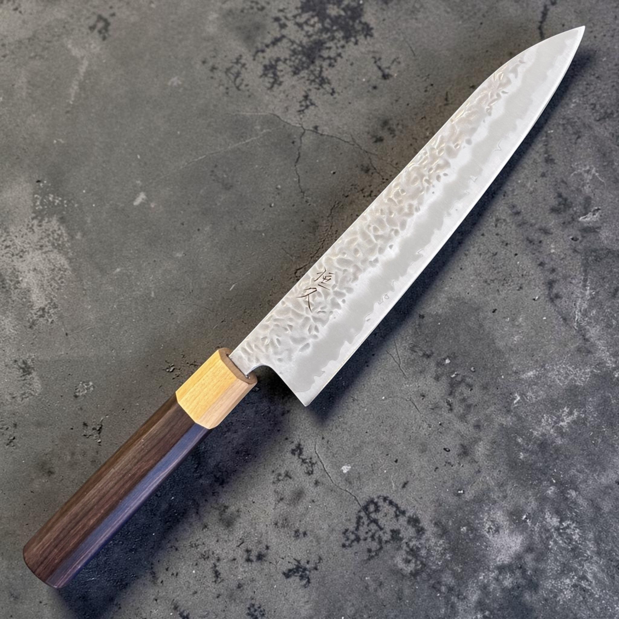 Tsunehisa White #1 stainless clad Tsuchime Gyuto 240 mm with ebony wa handle and light wood ferrule, angled full-knife product view.
