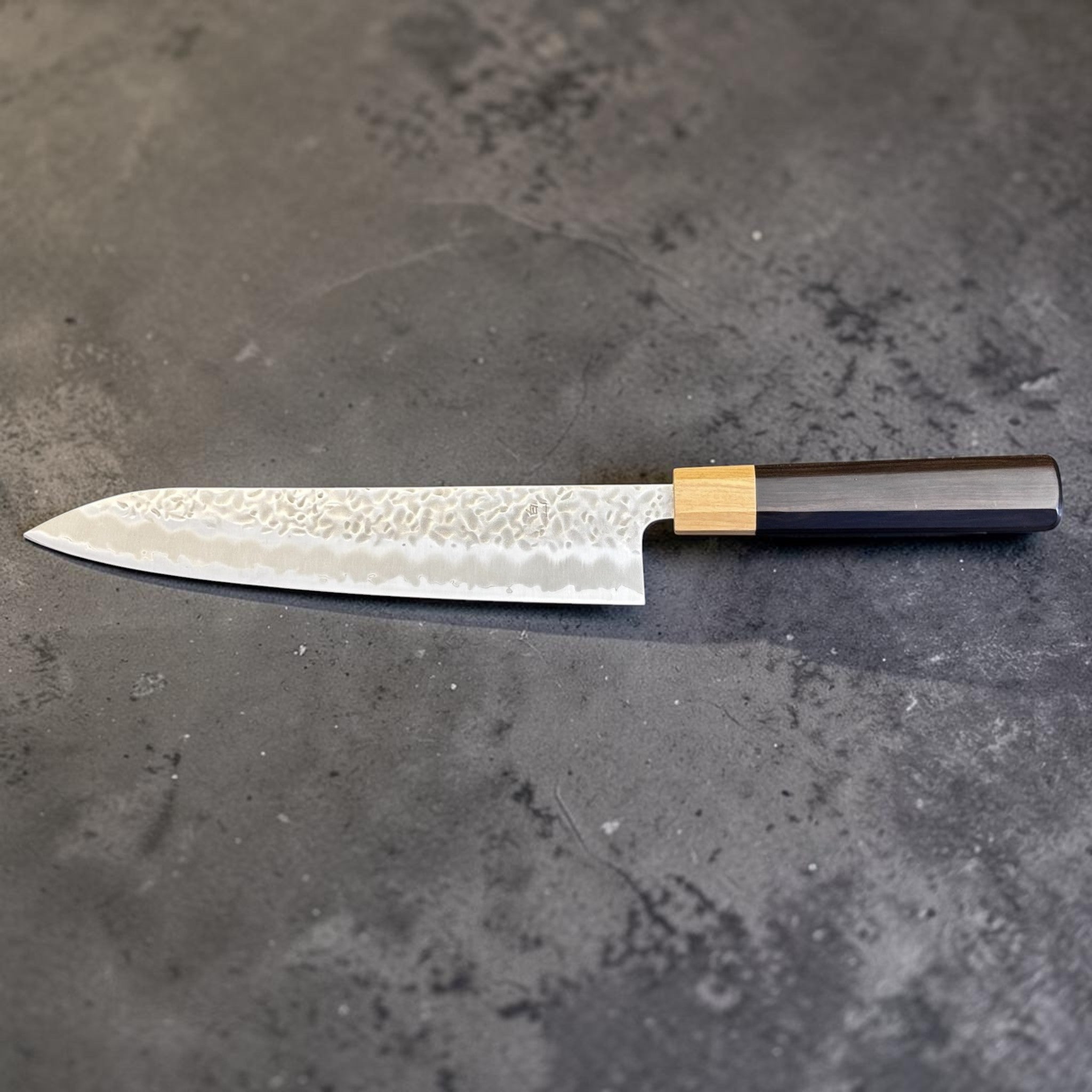 Tsunehisa White #1 stainless clad Tsuchime Gyuto 240 mm, reverse-side horizontal product photo with ebony handle and light wood ferrule.