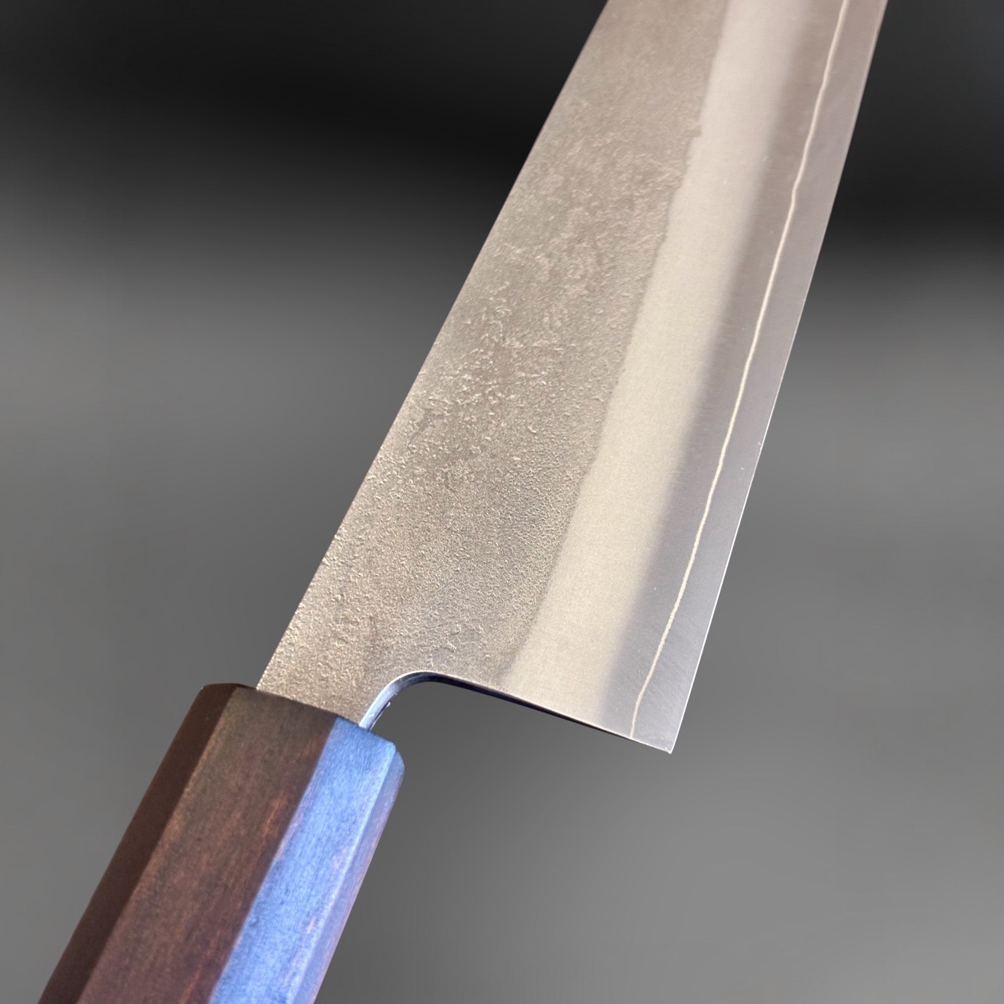 Yoshikane SKD Nashiji Gyuto 210 mm with mono ebony handle, close-up of nashiji blade finish and polished bevel.
