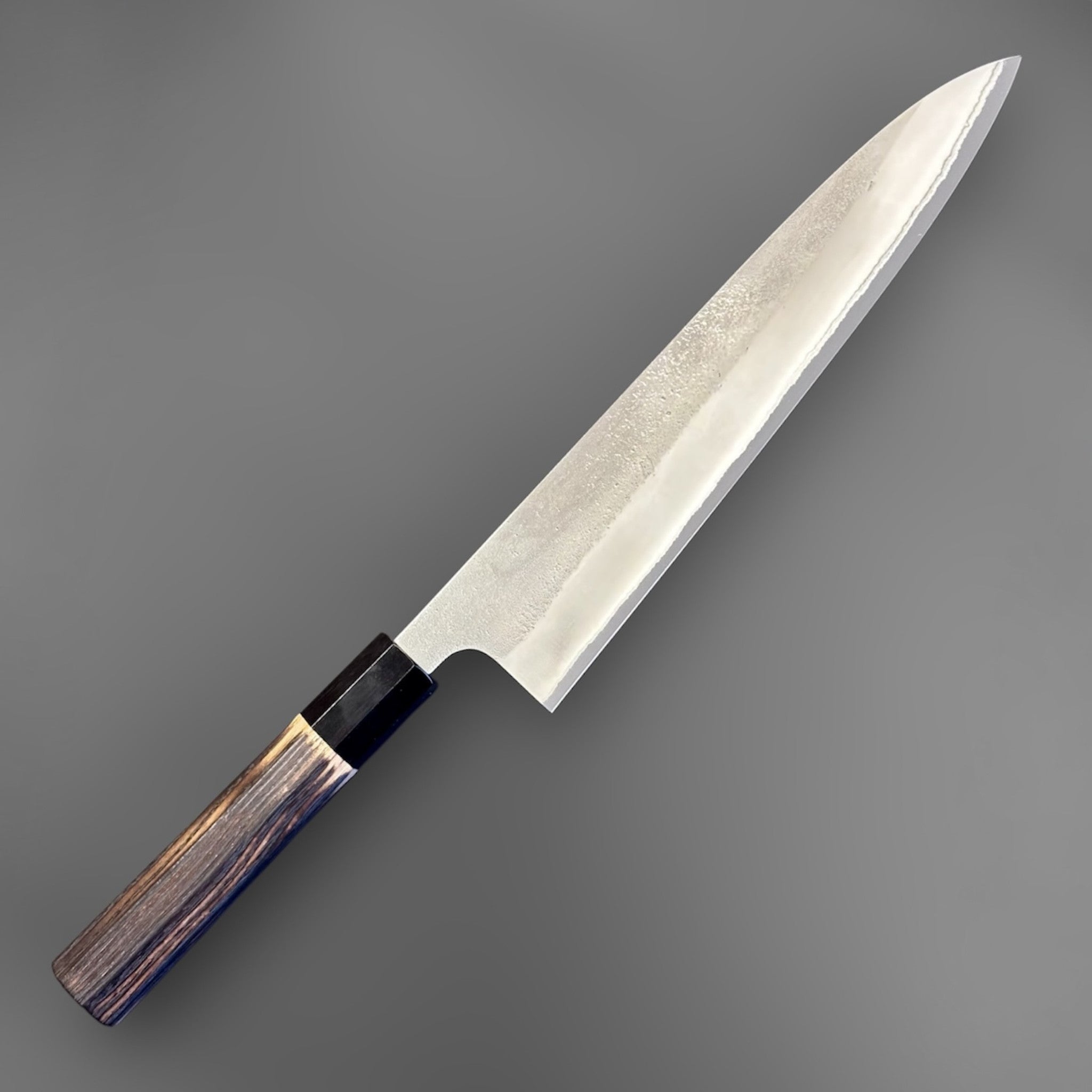 Yoshikane White #2 Nashiji Gyuto 240 mm, angled full-length view of the knife with octagonal burnt wood wa handle and black buffalo horn ferrule.
