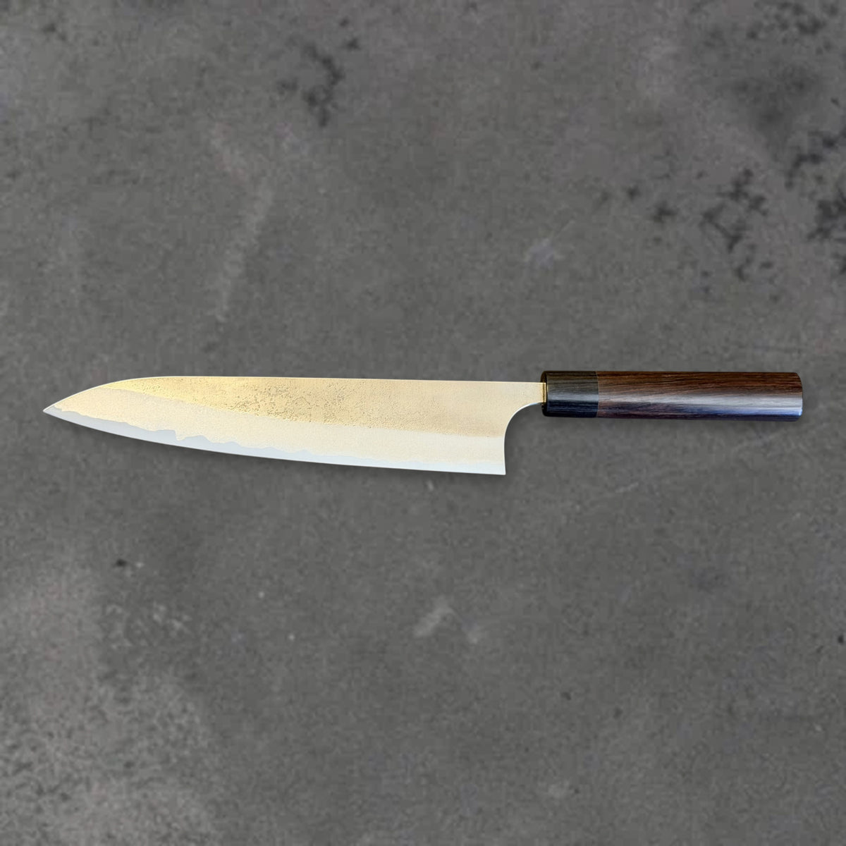 Reverse side of the Yoshimi Kato Aogami Super Nashiji 240mm gyuto in horizontal profile, with the blade tip on the left and dark wood handle on the right.