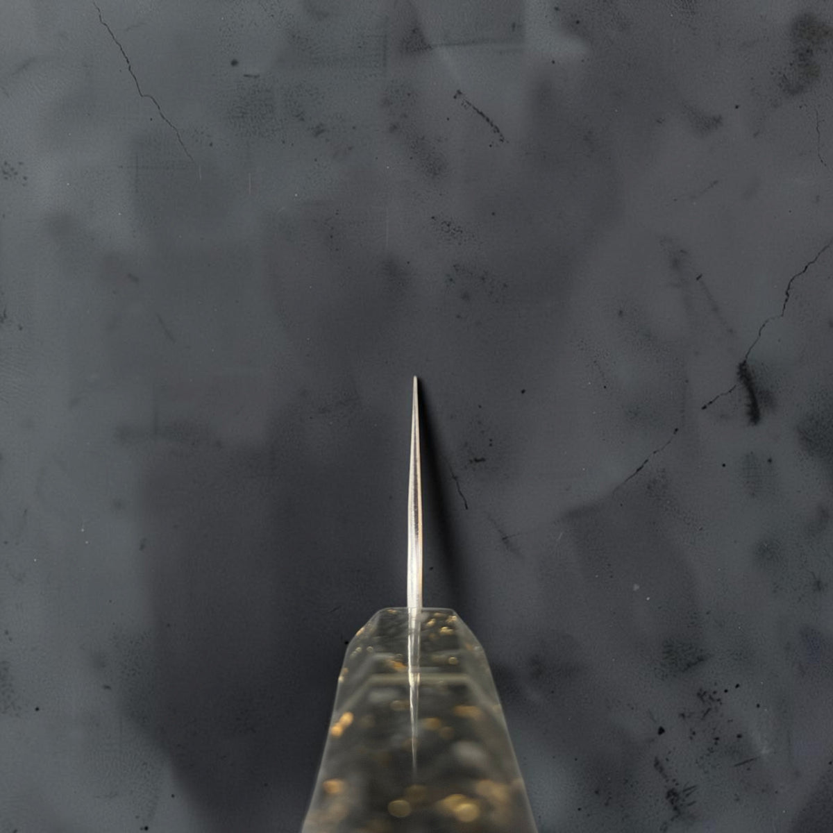Choil view of the Yoshimi Kato Minamo SG2 santoku showing its thin grind and carbon fiber gold-fleck handle.