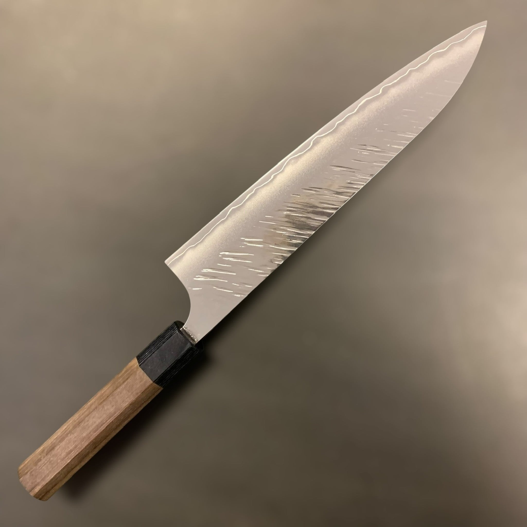 Yu Kurosaki Fujin SG2 Gyuto 210 mm, full knife with Fujin hammered pattern and visible kasumi line on a grey background.