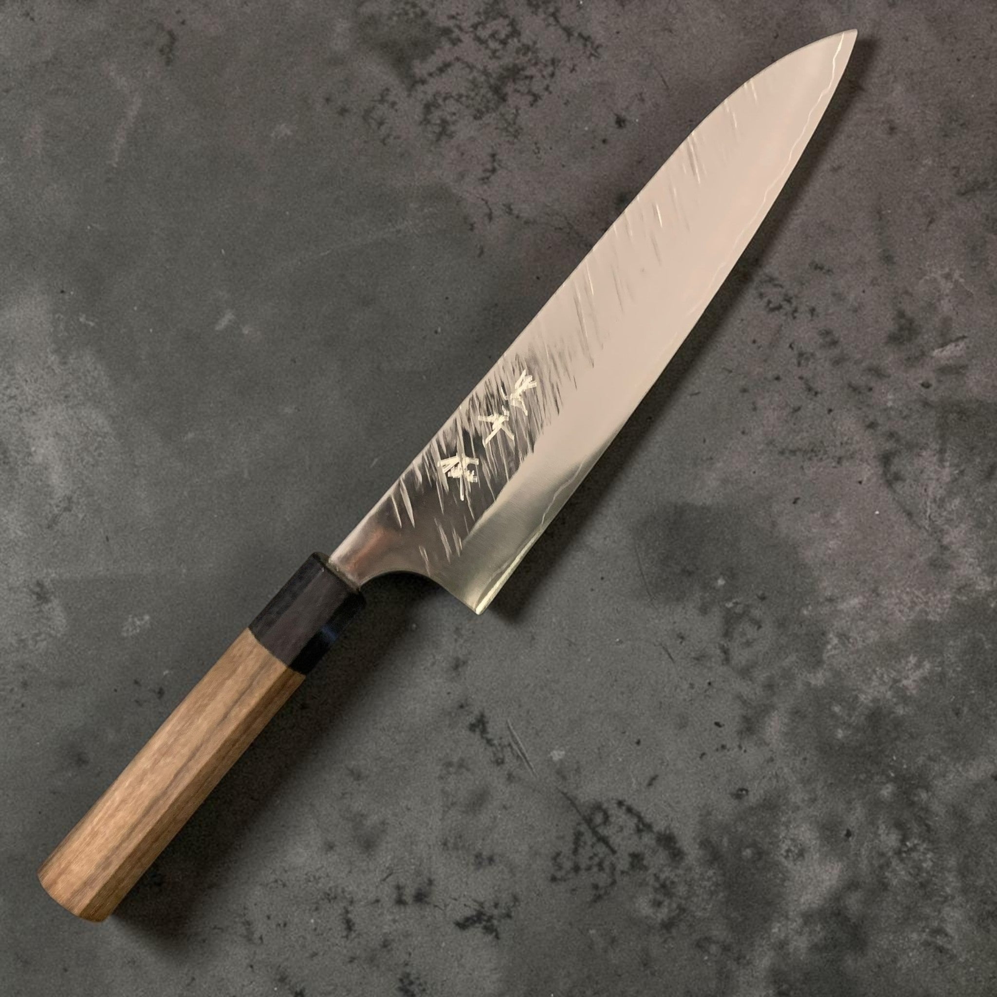 Yu Kurosaki Fujin SG2 Gyuto 210 mm, maker’s kanji and Fujin hammered pattern visible, full knife on a grey background.
