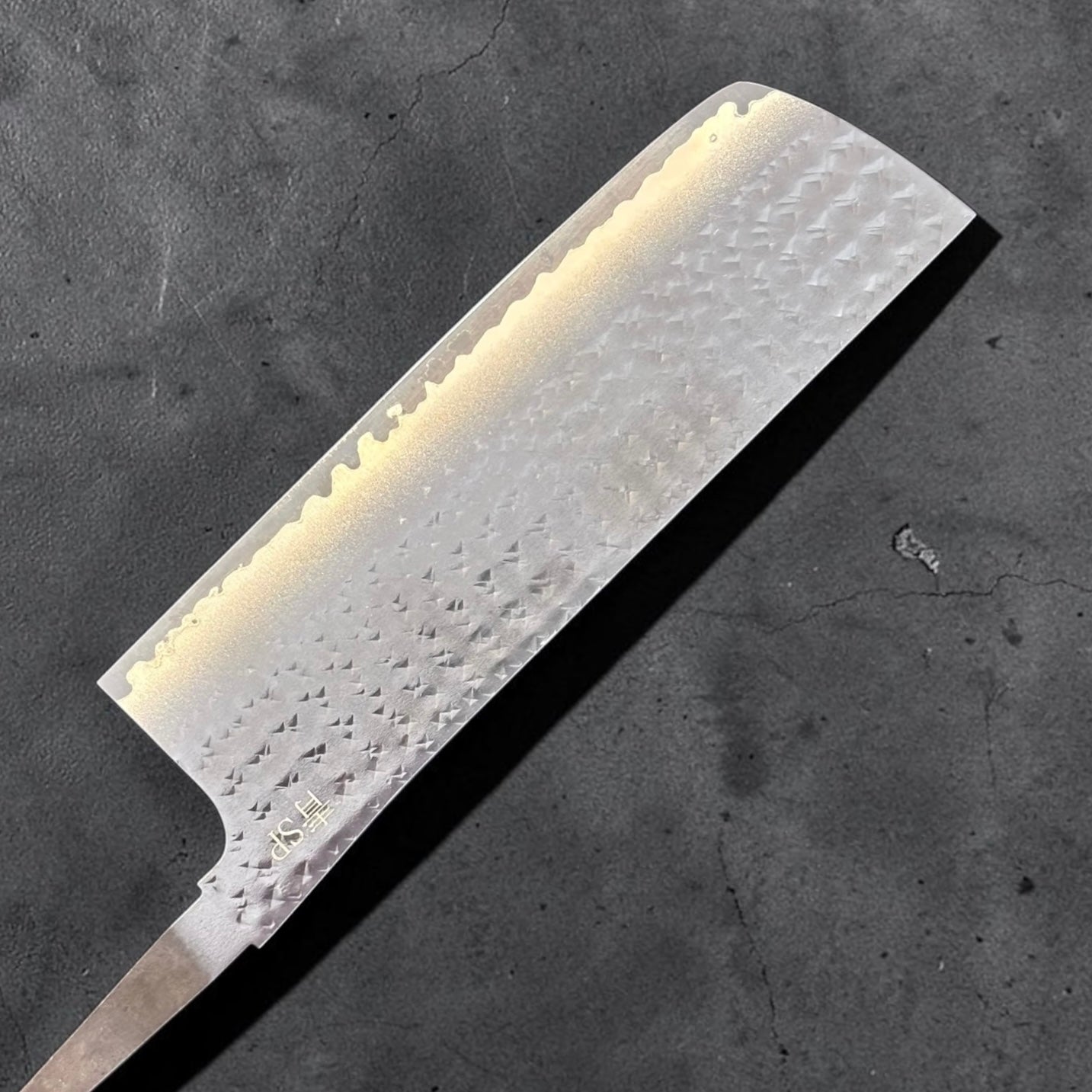 Reverse side of the Yu Kurosaki Kokusen AS Nakiri 165mm blade only showing the hammered finish