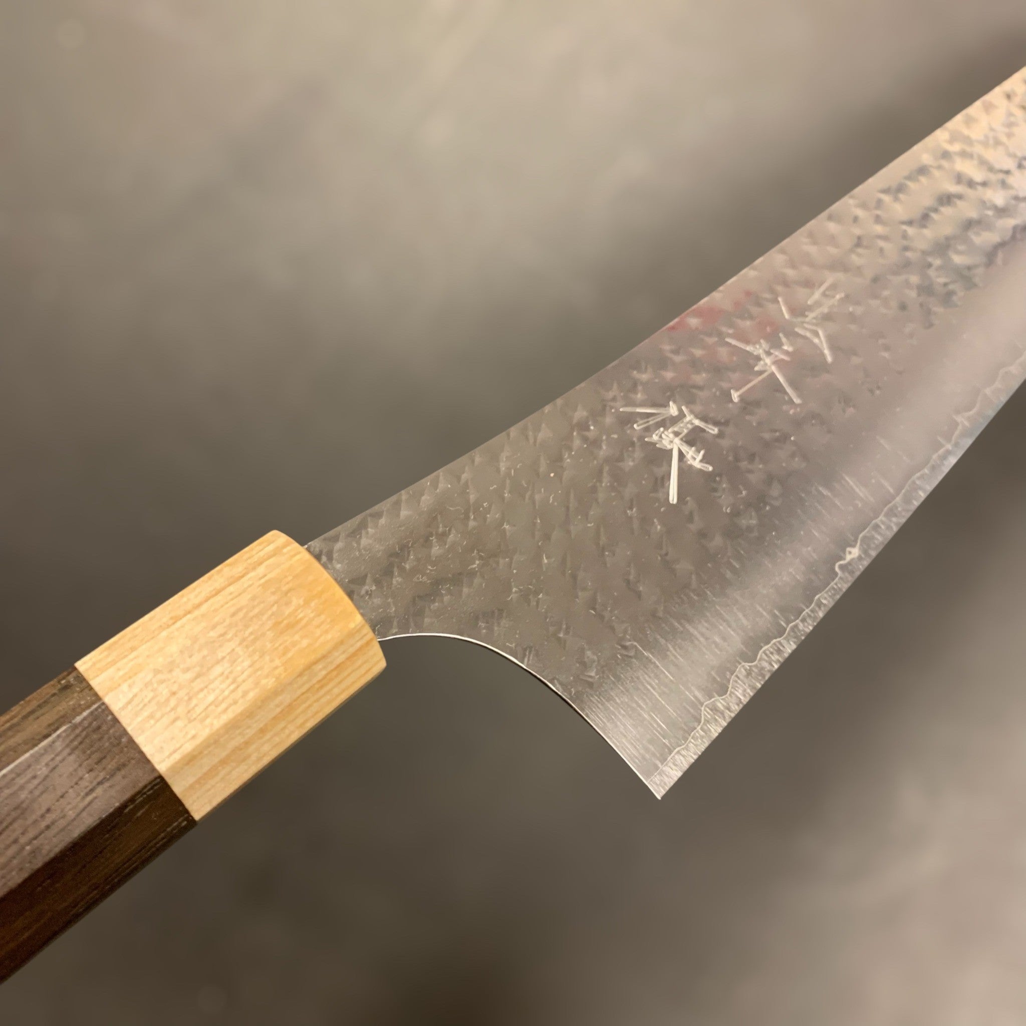 Yu Kurosaki Senko Ei SG2 Gyuto 240 mm — product angle highlighting tsuchime hammer pattern and satin hairline finish.