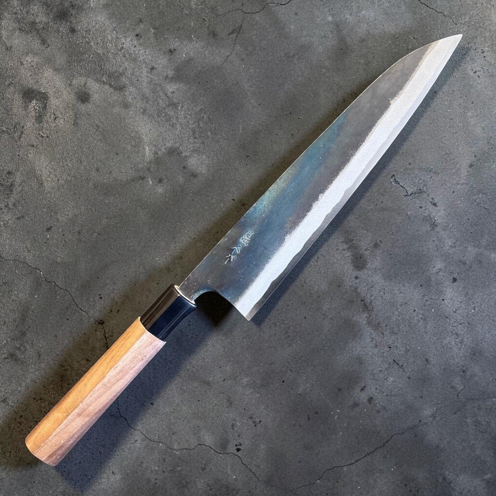 Zakuri AS Kurouchi Gyuto 210 mm, angled full-knife view showing the kurouchi blade finish and wa handle.