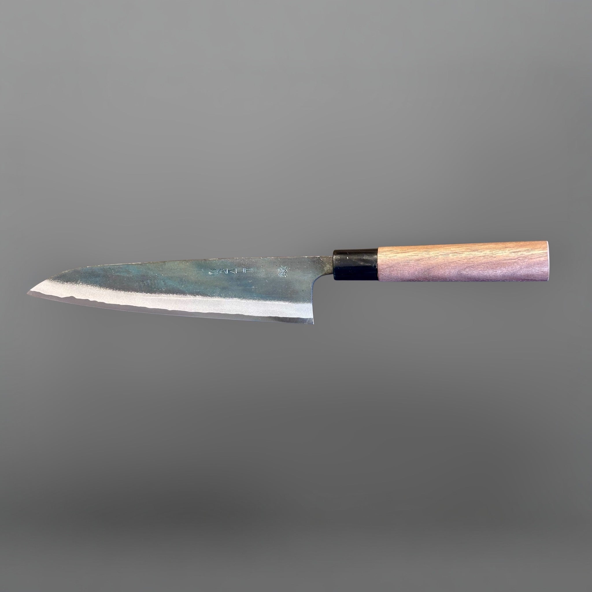 Zakuri AS Kurouchi Gyuto 210 mm, reverse-side horizontal profile showing the kurouchi blade and light wood wa handle.