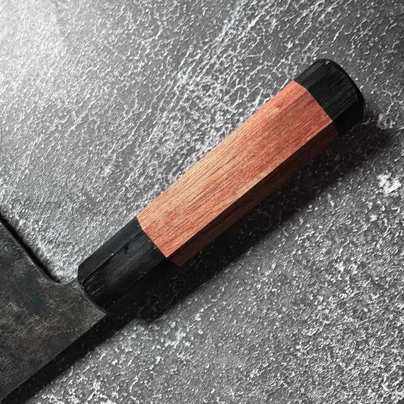Close-up of the FOOK KEE Model #1 Chinese Cleaver's wooden Wa handle on concrete