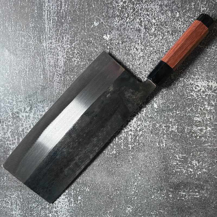 Angled view of FOOK KEE Model #1 Chinese Cleaver showcasing the blade and Wa handle on concrete